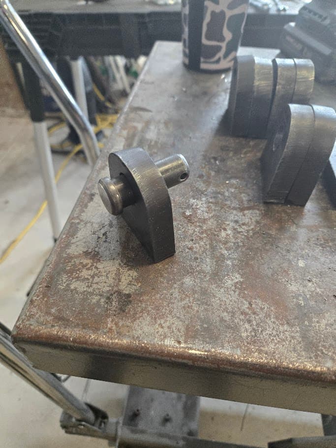 Small bracket batch 006 machined bracket parts staged on a metal table