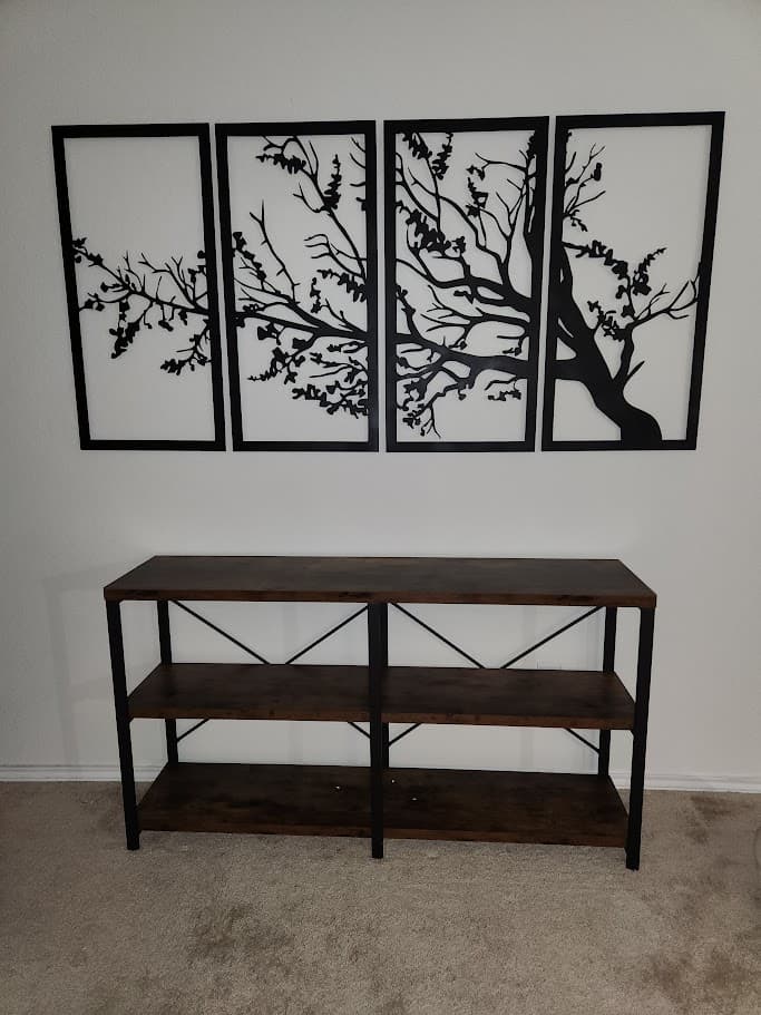 Four-panel plasma cut tree wall art installed above a console table